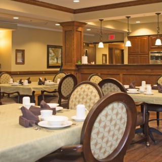 A cozy dining area with neatly arranged tables and chairs, featuring classic decor.
