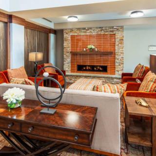 A cozy living room with wooden furniture and a brick fireplace.