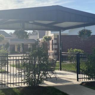 A sunny outdoor patio with a gazebo and hanging plants.