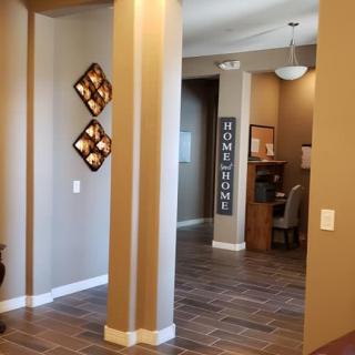 A warmly decorated hallway in a home with wooden flooring and wall art.