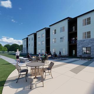 A modern apartment building with an outdoor patio area on a sunny day.