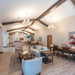 A spacious and modern living area featuring elegant furniture, wooden beams, and stylish lighting.