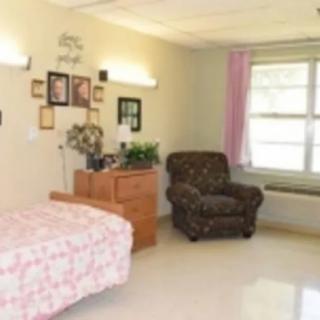 A cozy bedroom with a single bed, armchair, and decorative elements.