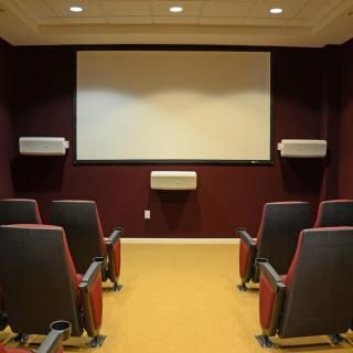 A cozy home theater setup with comfortable seating and a large screen.