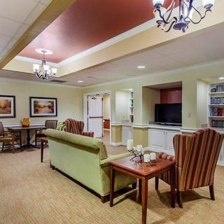 A cozy living room with comfortable seating, a television, and elegant lighting fixtures.