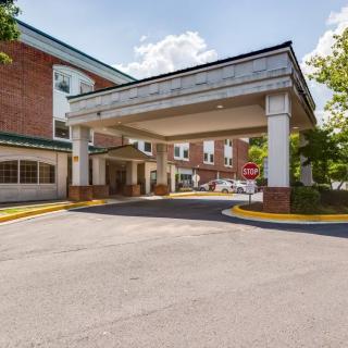 The entrance of a hotel with a covered driveway and brick facade.