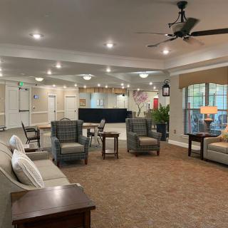 A spacious and well-lit lobby with comfortable seating areas and a carpeted floor.