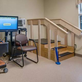A physical therapy room featuring exercise equipment and a small staircase for rehabilitation exercises.