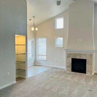 A spacious and modern living room featuring a cozy fireplace and ample natural light.