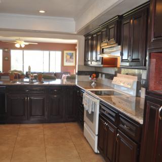 A spacious kitchen with dark cabinets and modern appliances.