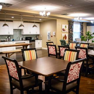 A modern and cozy dining area with a connected kitchen space and patterned chairs.