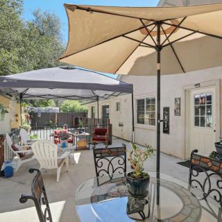 A sunny backyard patio with umbrellas and outdoor furniture.