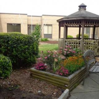 A peaceful garden area with a gazebo, colorful flowers, and well-maintained landscaping.
