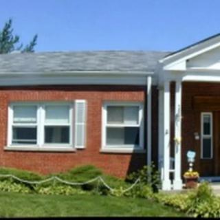 A single-story brick house with a front porch and windows.