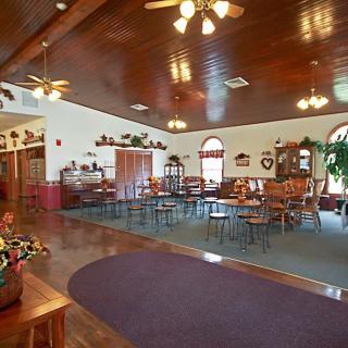Spacious restaurant dining area with wooden floors, ceiling fans, and decorative elements.