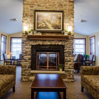 A cozy living room featuring a stone fireplace, elegant furniture, and warm lighting.