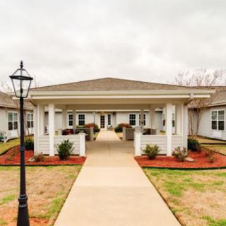 A welcoming pathway leads to the entrance of a neatly landscaped residential building.