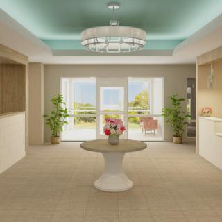 A modern living room with elegant design, featuring a chandelier, central table with flowers, and large windows letting in natural light.