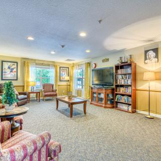 A cozy living room with comfortable seating, a television, and bookshelves filled with books.