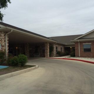 An exterior view of a brick building with an entrance and driveway.