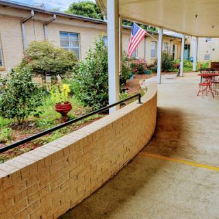 A peaceful outdoor courtyard featuring a garden and an American flag.