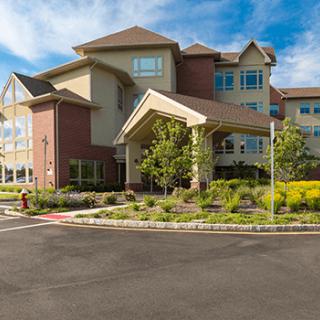 A residential building with landscaped surroundings under a clear blue sky.