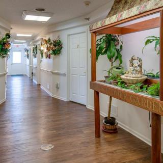 A decorated corridor with an aquarium and plants lining the walls.