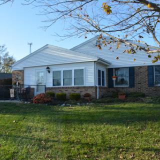 A charming single-story house with a well-maintained front yard.