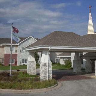 An exterior view of a building with a steeple and an American flag waving outside.