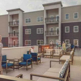 A rooftop terrace with outdoor seating in an apartment complex.