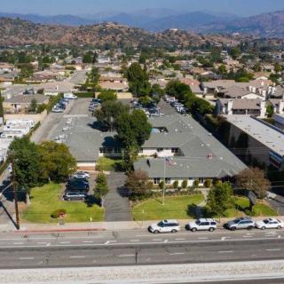 Aerial view of a suburban area with buildings, roads, and vehicles.
