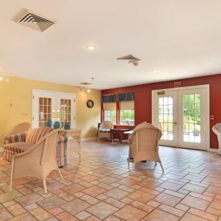 A bright and spacious living room with wicker furniture and large windows.