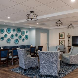 A modern living room interior with cozy seating and blue decor.