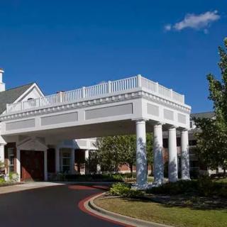 A modern building entrance with columns under a clear blue sky.