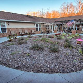 A well-maintained courtyard with a circular garden and seating area outside a building.
