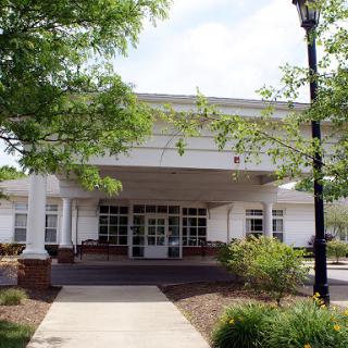 A welcoming entrance to a modern building, surrounded by greenery.