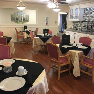 A cozy dining room with elegantly set tables and comfortable chairs.