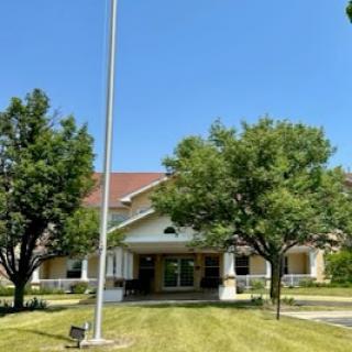 A charming building surrounded by lush greenery and a clear blue sky.