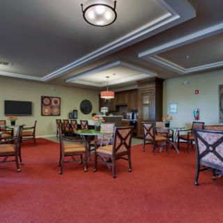 A spacious and well-lit dining area with elegant furniture and warm decor.