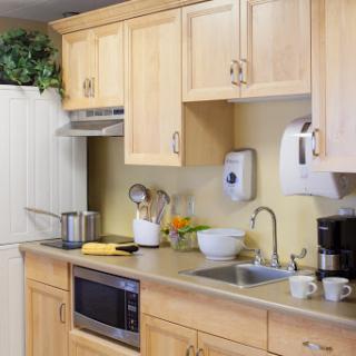 A well-equipped kitchen featuring wooden cabinets, a countertop with various appliances, and cooking essentials.