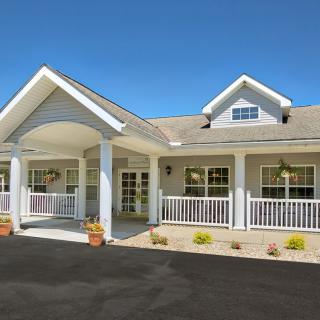 A charming residential building with a covered porch and a welcoming driveway.