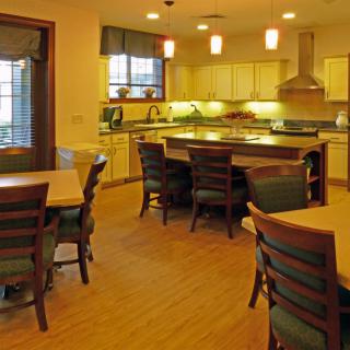 A modern kitchen and dining area with wooden furniture and ambient lighting.