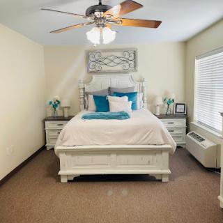 A beautifully arranged bedroom featuring a cozy bed, stylish decor, and ample natural light.