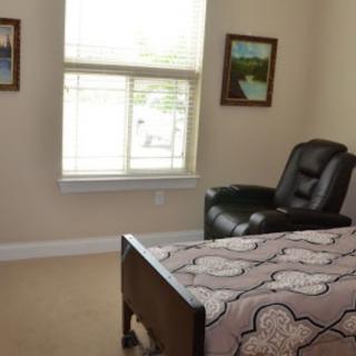 A cozy bedroom with a comfortable chair and art-adorned walls.