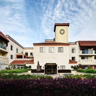 A beautiful residential building with a clock tower set against a backdrop of a vibrant blue sky.