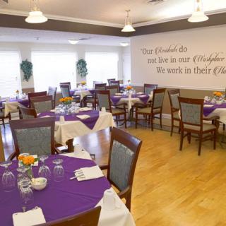 A cozy restaurant dining area with purple tablecloths and neatly arranged tables and chairs.