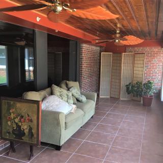 A cozy indoor space with a sofa, brick walls, and wooden ceiling.