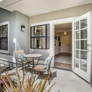 A cozy residential patio area with outdoor seating and French doors leading inside.