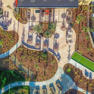 Aerial view of a landscaped garden with winding pathways and outdoor seating areas.