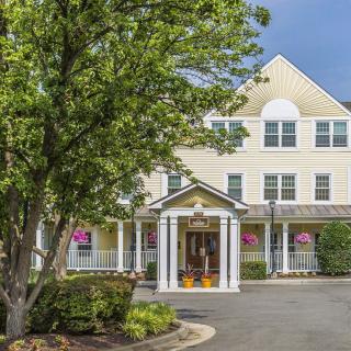 A charming residential building with a tree-lined entrance and well-maintained landscaping.